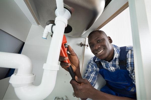 plumber fixing leaking pipe