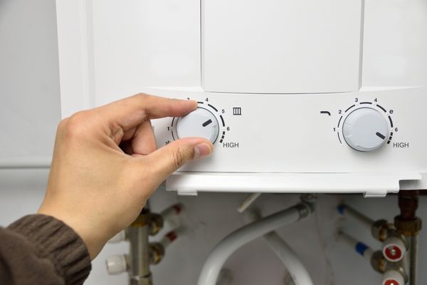 plumber adjusting boiler