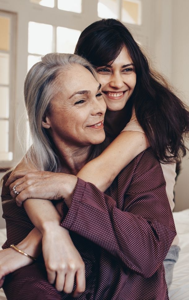 happy adult daughter holding her mother